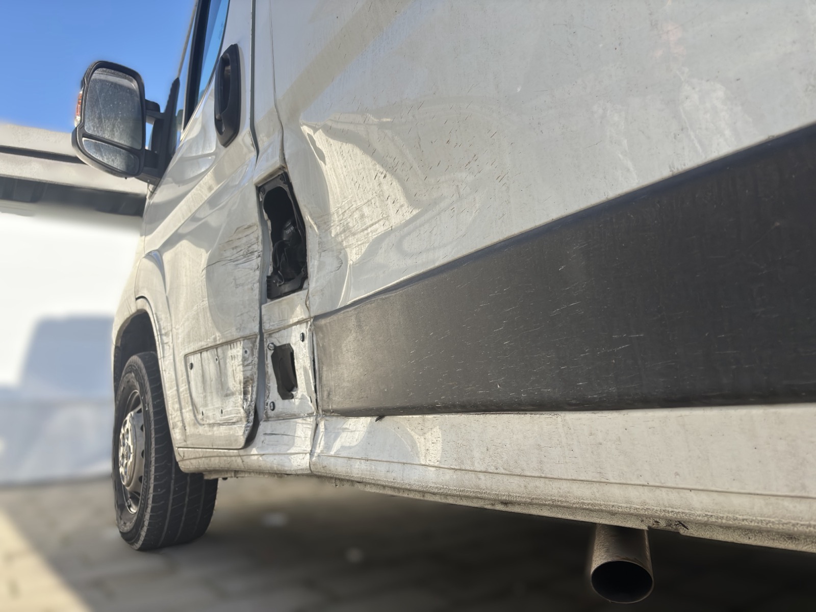 Seitenschaden an einem weißen Transporter