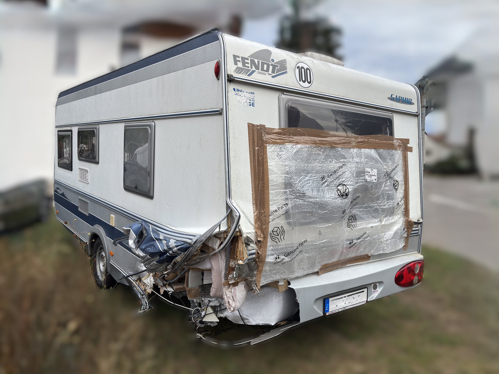 Aufgerissene Heckecke an einem Fendt Wohnwagen, provisorisch mit Folie abgedichtet