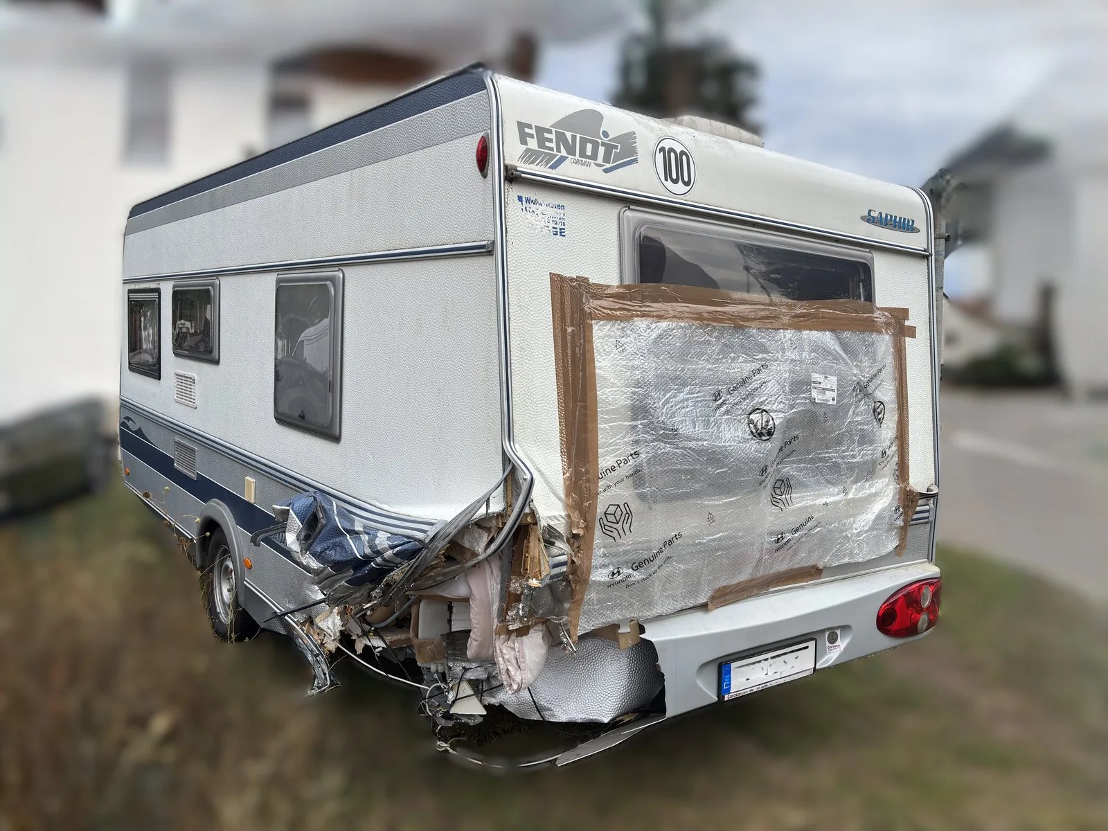 Aufgerissene Heckecke an einem Fendt Wohnwagen, provisorisch mit Folie abgedichtet
